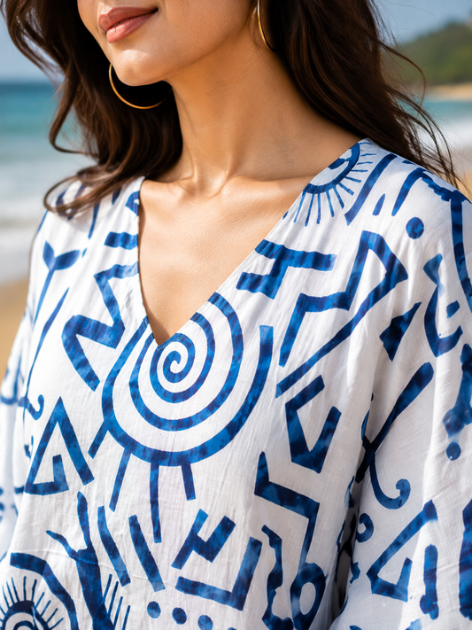 Woman sitting on beach chair wearing blue abstract print kaftan wide leg pants co-ord set